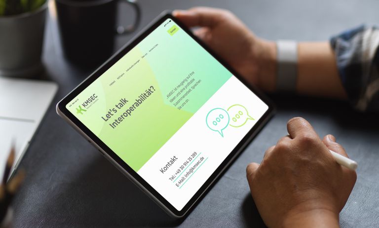 Webdesign KMSEC – Mann betrachtet Website auf iPad